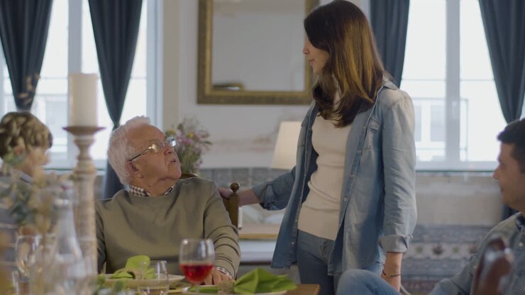 Family caregiver holding a loved one's hand at home